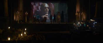 Movie still from “The Matrix Resurrections” (2021), directed by Lana Wachowski – Two men standing in front of a projection screen; Wide shot, Over the shoulder angle