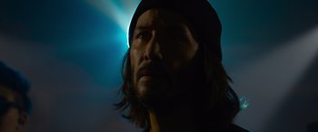 Movie still from “The Matrix Resurrections” (2021), directed by Lana Wachowski – A person with long hair wearing a hat; Close Up shot, Low angle