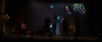 Movie still from “The Matrix Resurrections” (2021), directed by Lana Wachowski – A group of men standing in front of a projection screen; Wide shot, Over the shoulder angle