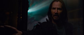 Movie still from “The Matrix Resurrections” (2021), directed by Lana Wachowski – A man with long black hair and a black jacket; Close Up shot, Over the shoulder angle