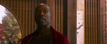 Movie still from “The Matrix Resurrections” (2021), directed by Lana Wachowski – A man in a red shirt is looking at the camera; Close Up shot, Low angle