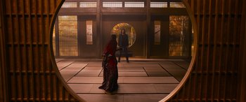 Movie still from “The Matrix Resurrections” (2021), directed by Lana Wachowski – Two people are standing in front of an open door; Extreme Wide shot, Over the shoulder angle