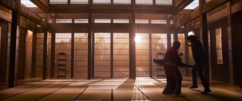 Movie still from “The Matrix Resurrections” (2021), directed by Lana Wachowski – A person is standing in front of a window; Extreme Wide shot, Low angle