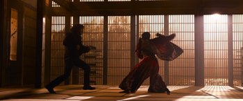Movie still from “The Matrix Resurrections” (2021), directed by Lana Wachowski – A man and a woman are dancing in front of a cage; Wide shot, Low angle
