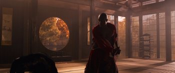 Movie still from “The Matrix Resurrections” (2021), directed by Lana Wachowski – A man in a red robe holding a sword; Wide shot, Low angle