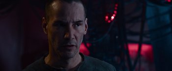 Movie still from “The Matrix Resurrections” (2021), directed by Lana Wachowski – A person wearing a gray shirt; Close Up shot, Over the shoulder angle