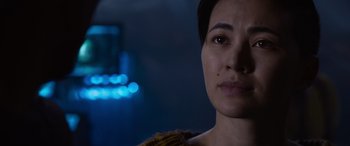 Movie still from “The Matrix Resurrections” (2021), directed by Lana Wachowski – A woman's face in the dark; Close Up shot, Over the shoulder angle