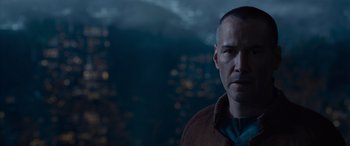 Movie still from “The Matrix Resurrections” (2021), directed by Lana Wachowski – A person wearing a brown jacket; Close Up shot, Over the shoulder angle