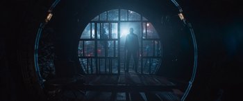 Movie still from “The Matrix Resurrections” (2021), directed by Lana Wachowski – A man standing in front of an opening in a building; Wide shot, Low angle