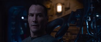 Movie still from “The Matrix Resurrections” (2021), directed by Lana Wachowski – A person holding a metal object; Close Up shot, High angle