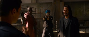 Movie still from “The Matrix Resurrections” (2021), directed by Lana Wachowski – A group of men standing next to each other holding guns; Medium shot, Low angle