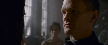 Movie still from “The Matrix Resurrections” (2021), directed by Lana Wachowski – A man's face with a woman in the background; Close Up shot, Over the shoulder angle