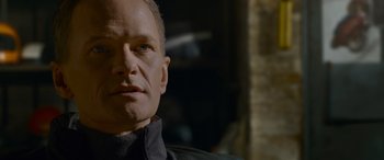 Movie still from “The Matrix Resurrections” (2021), directed by Lana Wachowski – A man's face in a black jacket; Close Up shot, Over the shoulder angle