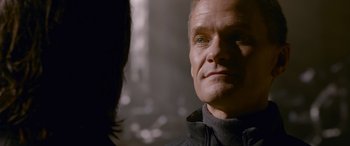 Movie still from “The Matrix Resurrections” (2021), directed by Lana Wachowski – A man that is looking into the camera; Close Up shot, Over the shoulder angle