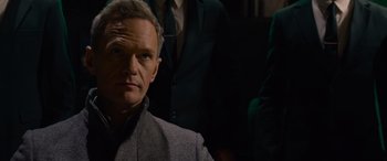 Movie still from “The Matrix Resurrections” (2021), directed by Lana Wachowski – A man in a suit and tie standing next to another man in a suit and tie; Close Up shot, Over the shoulder angle