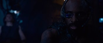 Movie still from “The Matrix Resurrections” (2021), directed by Lana Wachowski – A person wearing headphones and glasses; Close Up shot, Low angle