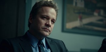 Movie still from “Dopesick” (2021), directed by Danny Strong – A person wearing a suit and tie; Close Up shot, Over the shoulder angle