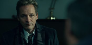 Movie still from “Dopesick” (2021), directed by Danny Strong – A person wearing a suit and tie; Close Up shot, Over the shoulder angle