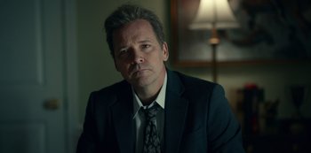 Movie still from “Dopesick” (2021), directed by Danny Strong – A person wearing a suit and tie; Close Up shot, Low angle