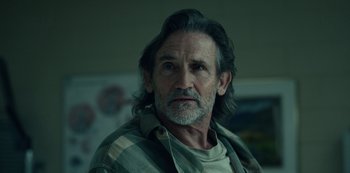 Movie still from “Dopesick” (2021), directed by Danny Strong – An older man with long hair and a beard; Close Up shot, Over the shoulder angle