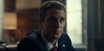 Movie still from “Dopesick” (2021), directed by Danny Strong – A person wearing a suit and tie; Close Up shot, Low angle