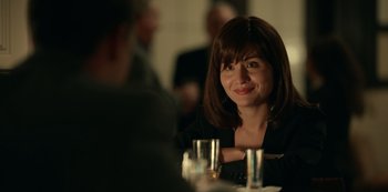 Movie still from “Dopesick” (2021), directed by Danny Strong – A woman sitting at a table with a glass in front of her; Close Up shot, Over the shoulder angle