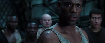 Movie still from “The Matrix Revolutions” (2003), directed by Lilly Wachowski – A man's face in front of two other men; Close Up shot, Low angle