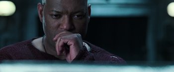 Movie still from “The Matrix Revolutions” (2003), directed by Lilly Wachowski – A man sitting in front of a computer monitor; Close Up shot, Low angle