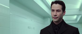 Movie still from “The Matrix Revolutions” (2003), directed by Lilly Wachowski – A man in a black suit and a black tie; Close Up shot, Over the shoulder angle