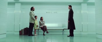 Movie still from “The Matrix Revolutions” (2003), directed by Lilly Wachowski – A group of people sitting on a bench in a room; Wide shot, Low angle