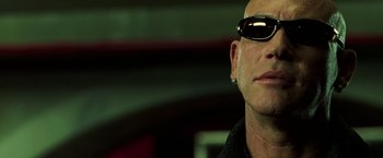 Movie still from “The Matrix Revolutions” (2003), directed by Lilly Wachowski – A person wearing sunglasses; Close Up shot, Low angle