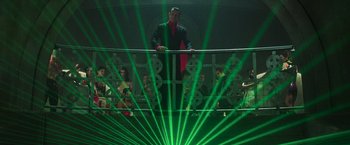 Movie still from “The Matrix Revolutions” (2003), directed by Lilly Wachowski – A man standing on top of a railing in front of a bunch of people; Wide shot, Low angle