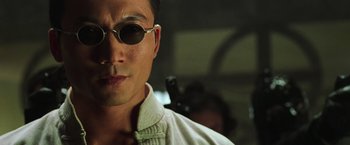 Movie still from “The Matrix Revolutions” (2003), directed by Lilly Wachowski – A person wearing sunglasses; Close Up shot, Low angle