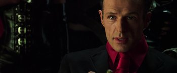 Movie still from “The Matrix Revolutions” (2003), directed by Lilly Wachowski – A person wearing a suit and tie; Close Up shot, Over the shoulder angle