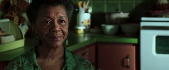 Movie still from “The Matrix Revolutions” (2003), directed by Lilly Wachowski – An older woman in a green shirt in a kitchen; Close Up shot, Low angle