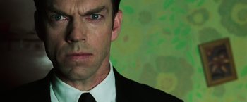 Movie still from “The Matrix Revolutions” (2003), directed by Lilly Wachowski – A person wearing a suit and tie; Close Up shot, Low angle