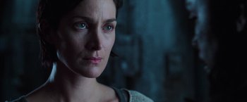 Movie still from “The Matrix Revolutions” (2003), directed by Lilly Wachowski – A woman's face in a dark room; Close Up shot, Over the shoulder angle