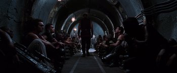 Movie still from “The Matrix Revolutions” (2003), directed by Lilly Wachowski – A group of people sitting in a tunnel; Wide shot, High angle