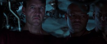 Movie still from “The Matrix Revolutions” (2003), directed by Lilly Wachowski – Two men standing next to each other in the dark; Close Up shot, Low angle