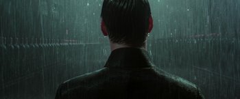 Movie still from “The Matrix Revolutions” (2003), directed by Lilly Wachowski – A man standing in front of a window in the rain; Close Up shot, Over the shoulder angle