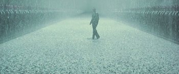 Movie still from “The Matrix Revolutions” (2003), directed by Lilly Wachowski – A man walking in the rain with a umbrella; Extreme Wide shot, High angle