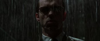 Movie still from “The Matrix Revolutions” (2003), directed by Lilly Wachowski – A person wearing a suit and tie; Close Up shot, Low angle
