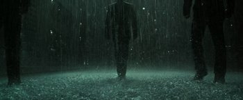 Movie still from “The Matrix Revolutions” (2003), directed by Lilly Wachowski – A man standing in the rain in front of some lights; Extreme Wide shot, Low angle