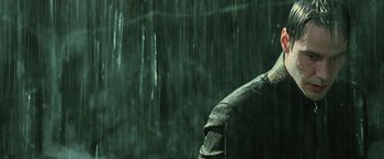 Movie still from “The Matrix Revolutions” (2003), directed by Lilly Wachowski – A person standing in the middle of a rain storm; Close Up shot, Low angle