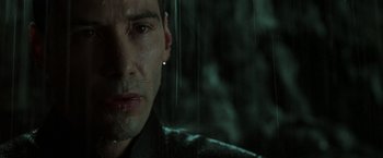Movie still from “The Matrix Revolutions” (2003), directed by Lilly Wachowski – A man's face in the rain; Close Up shot, Over the shoulder angle