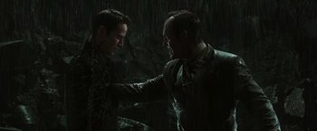 Movie still from “The Matrix Revolutions” (2003), directed by Lilly Wachowski – Two men in the rain , one of whom is holding the hand of another man; Medium shot, Over the shoulder angle