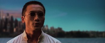 Movie still from “The Matrix Revolutions” (2003), directed by Lilly Wachowski – A person wearing a white shirt and sunglasses; Close Up shot, Low angle