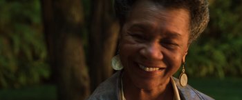 Movie still from “The Matrix Revolutions” (2003), directed by Lilly Wachowski – An older woman smiling with her eyes closed; Close Up shot, Low angle