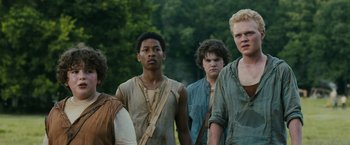 Movie still from “The Maze Runner” (2014), directed by Wes Ball – A group of young men standing next to each other in front of trees; Medium shot, Over the shoulder angle