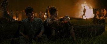 Movie still from “The Maze Runner” (2014), directed by Wes Ball – Two young men sitting in the grass at night; Medium shot, Over the shoulder angle